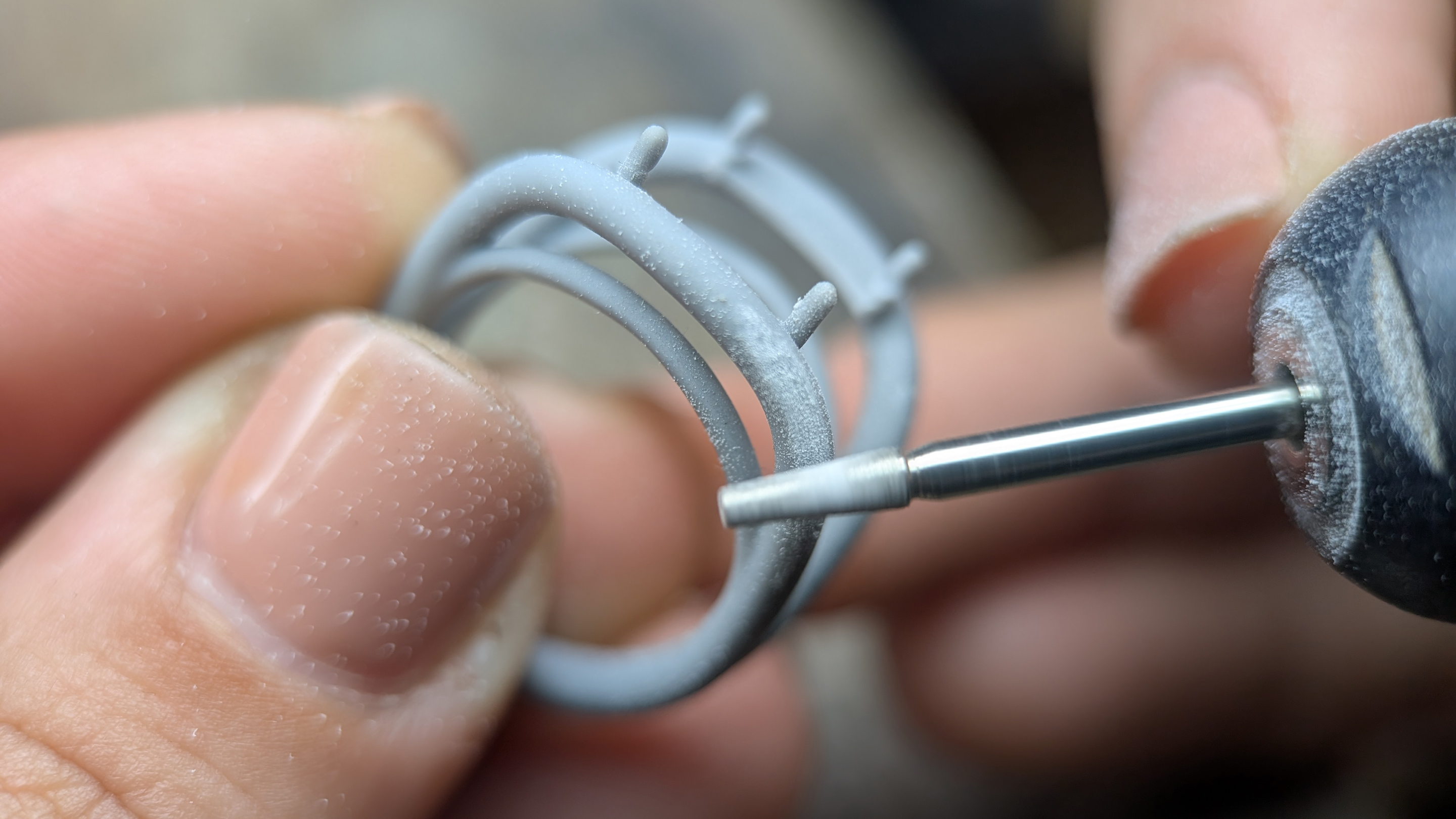 Grey jewellery prototype held against a micromotor handpiece